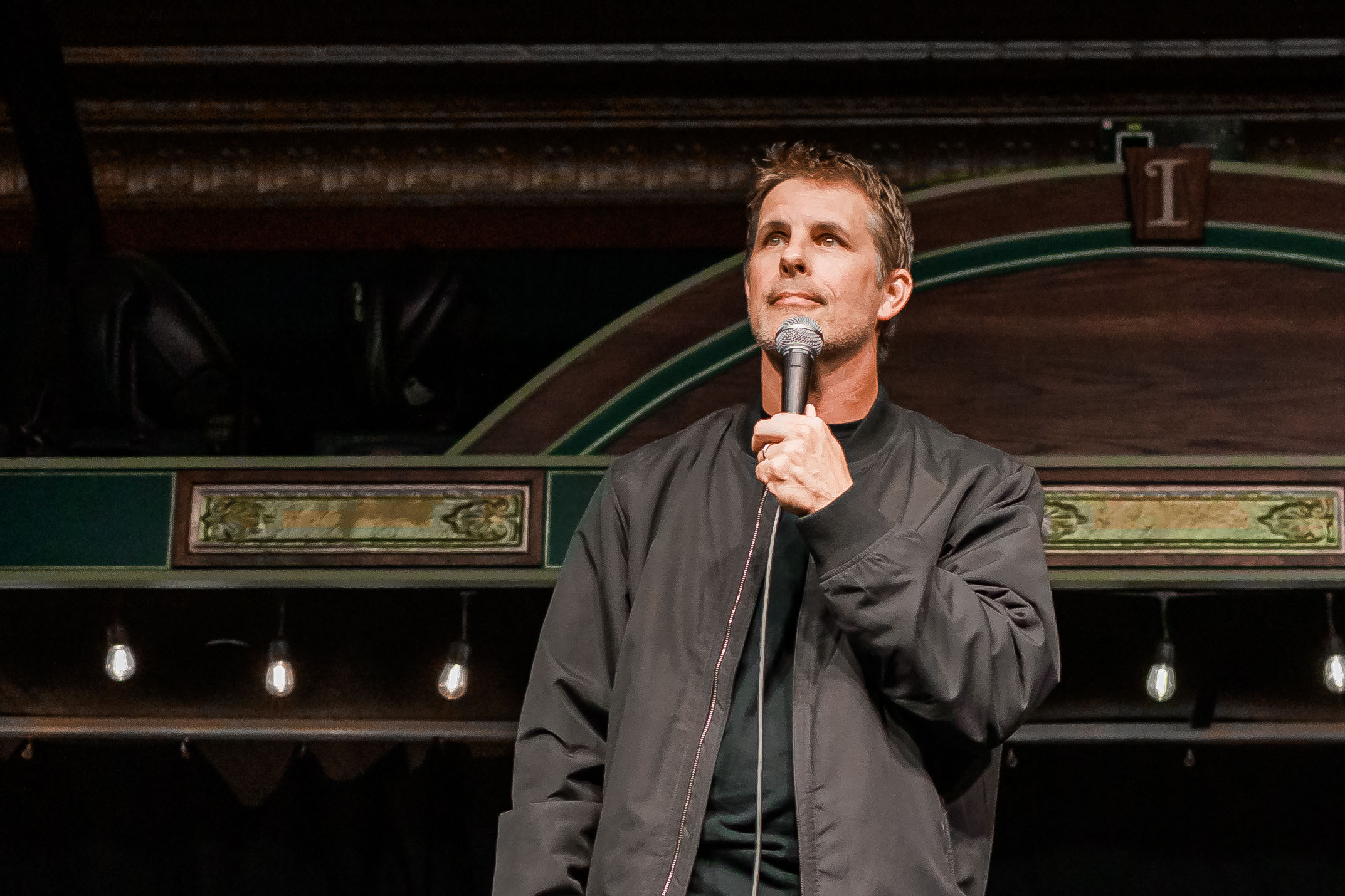 Nathan Timmel, Corporate Comedian, performing on stage in a vintage theater